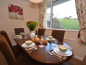 a dining room table with chairs and a large window at 2 Bed in Bideford oc-sandb in Instow