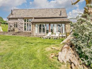 a stone house with white chairs in the yard at 2 Bed in Abergavenny oc-66630 in Dorstone