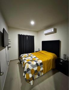 a bedroom with a bed with a yellow blanket at Casa en Privada! in Culiacán +8 photos