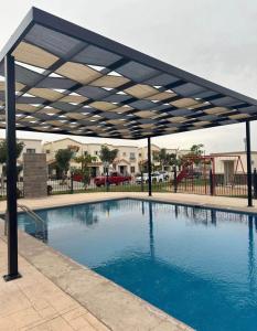 a large swimming pool with a canopy over it at Casa en Privada! in Culiacán