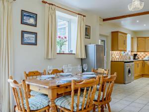 a dining room with a table and chairs and a kitchen at 3 Bed in Builth Wells oc-52463 in Alltmawr