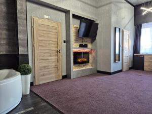 a room with a fireplace and a door with a tv at Penzion Vulture Ostrava in Ostrava +54 photos