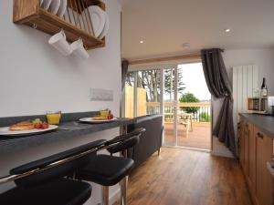 a kitchen with a counter with chairs and a table at 1 Bed in Bideford oc-74817 in Bideford