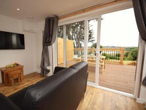 a living room with a couch and a large sliding glass door at 1 Bed in Bideford oc-74817 in Bideford +8 photos