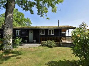 a black house with a porch and a tree at 3 Bed in Hereford oc-bn141 in Clyro