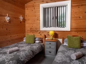 two twin beds in a room with wooden walls at 3 Bed in Hereford oc-bn141 in Clyro