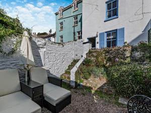 a patio with a chair and an umbrella and a building at 1 Bed in Brixham oc-bx036 in Brixham
