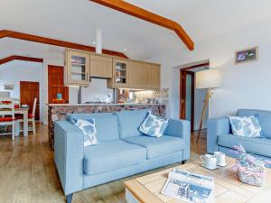a living room with two blue couches and a kitchen at 2 Bed in Wellington oc-00467 in West Buckland