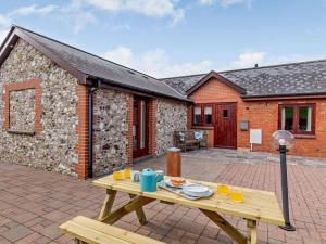 a wooden picnic table in front of a stone cottage at 2 Bed in Wellington oc-00467 in West Buckland