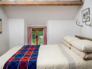 a bedroom with a bed with a quilt on it at 3 Bed in Hay-on-wye oc-bn070 in Hay-on-Wye