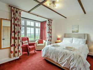 a bedroom with a bed and a chair and a window at 3 Bed in Bideford oc-bybur in Bideford +22 photos