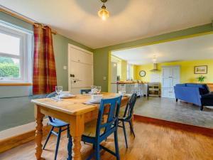 a dining room with a wooden table and blue chairs at 2 Bed in Egremont oc-87227 in Egremont +14 photos