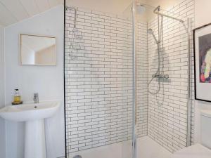 a white bathroom with a shower and a sink at 2 Bed in Chepstow oc-42837 in Wolves Newton +23 photos