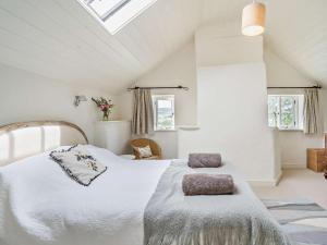a bedroom with a large white bed and two windows at 2 Bed in Chepstow oc-42837 in Wolves Newton