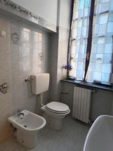 a bathroom with a white toilet and a sink at B&B La Casa di Olga in Bobbio