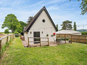 a white barn with a deck and a fence at 1 Bed in Pontypool oc-83405 in Mamhilad