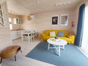 a living room with a yellow couch and a table at DESTINO wakacyjne domki-dwa podgrzewane baseny-drink bar in Mielno
