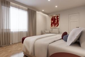 a white bedroom with two beds and a window at The Character in Athens +3 photos