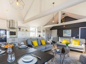 a kitchen and living room with a table and yellow pillows at 4 Bed in Bideford oc-86776 in Appledore
