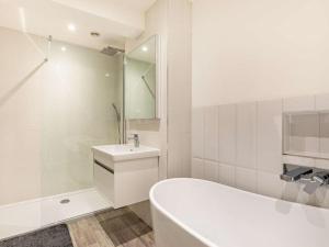 a white bathroom with a tub and a sink at 4 Bed in Bideford oc-86776 in Appledore