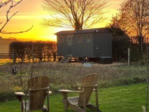 two chairs sitting in the grass with a building at 1 Bed in Stockport oc-87592 in Mellor