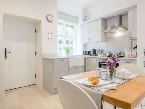 a kitchen with a wooden table and white cabinets at 1 Bed in Brecon oc-88748 in Aber-Brân
