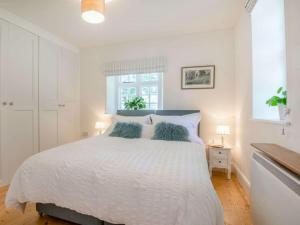 a white bedroom with a white bed and a window at 1 Bed in Brecon oc-88748 in Aber-Brân
