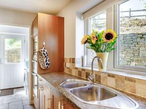 a kitchen with a sink and a vase of flowers at 5 Bed in Matlock oc-88486 in Crich +17 photos