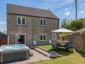 a house with a pool and a table and an umbrella at 5 Bed in Matlock oc-88486 in Crich