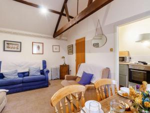 a living room with a blue couch and a table at 2 Bed in Abergavenny oc-90235 in Llanvetherine