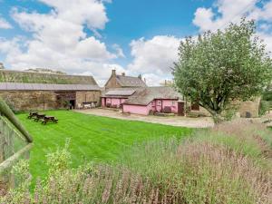 a group of buildings with a green yard with benches at 2 Bed in Abergavenny oc-90235 in Llanvetherine