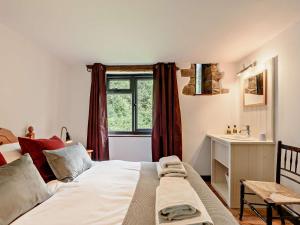a bedroom with a bed with a sink and a window at 3 Bed in Llandovery oc-bn093 in Llandovery