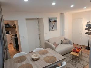 a living room with a table and a couch at Centre Chambéry - Parking gratuit - tout inclus in Chambéry