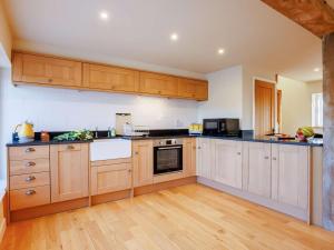 a large kitchen with wooden cabinets and appliances at 1 Bed in Faringdon oc-88573 in Coxwell