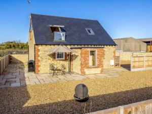 a small brick house with an umbrella in front of it at 1 Bed in Faringdon oc-88573 in Coxwell