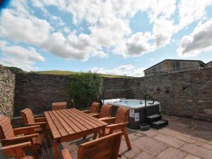 a patio with a table and chairs and a hot tub at 5 Bed in Brecon oc-90660 in Lower Chapel