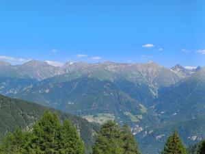 a view of a mountain range with trees in the foreground at Hof am Berg in Kaunerberg