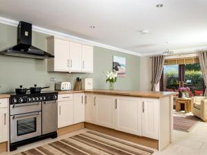 a kitchen with white cabinets and a stove at 4 Bed in Ystradgynlais oc-bn343 in Ystalyfera