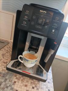 a coffee maker with a cup of coffee on a counter at Chata košaríska in Oščadnica