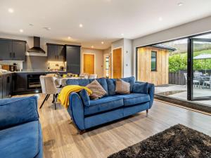 a living room with a blue couch and a kitchen at 2 Bed in Knighton oc-94202 in Knighton