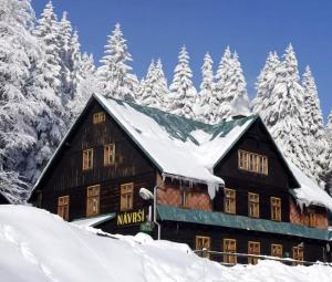 a building covered in snow with snow covered trees at Chata Návrší in Stříbrnice