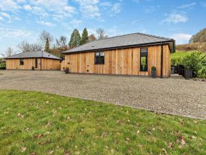 a large wooden house with a gravel driveway at 2 Bed in Knighton oc-94202 in Knighton