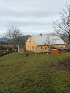 a large yellow house on a grassy field at Chata košaríska in Oščadnica