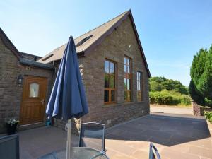a blue umbrella sitting in front of a house at 2 Bed in Abergavenny oc-65965 in Pandy