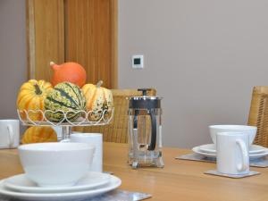 a table with a coffee maker and a bowl of pumpkins at 2 Bed in Abergavenny oc-65965 in Pandy +17 photos