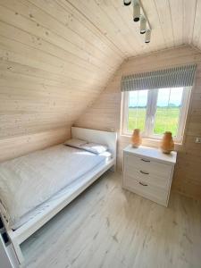 a small bedroom with a bed and a window at DESTINO wakacyjne domki-dwa podgrzewane baseny-drink bar in Mielno +44 photos