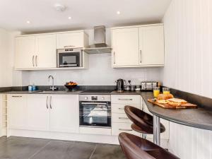 a kitchen with white cabinets and a counter top at 1 Bed in Barnstaple oc-77349 in Loxhore +9 photos