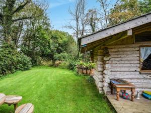a log cabin with a bench next to a yard at 3 Bed in North Tawton oc-66043 in Winkleigh