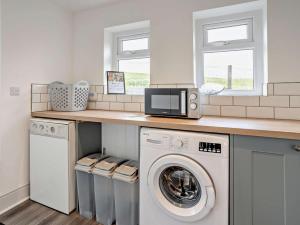 a kitchen with a washer and dryer under a counter at 3 Bed in Brecon oc-96240 in Llandefaelogfâch