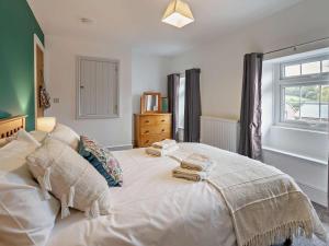 a bedroom with a large white bed with towels on it at 3 Bed in Brecon oc-96240 in Llandefaelogfâch